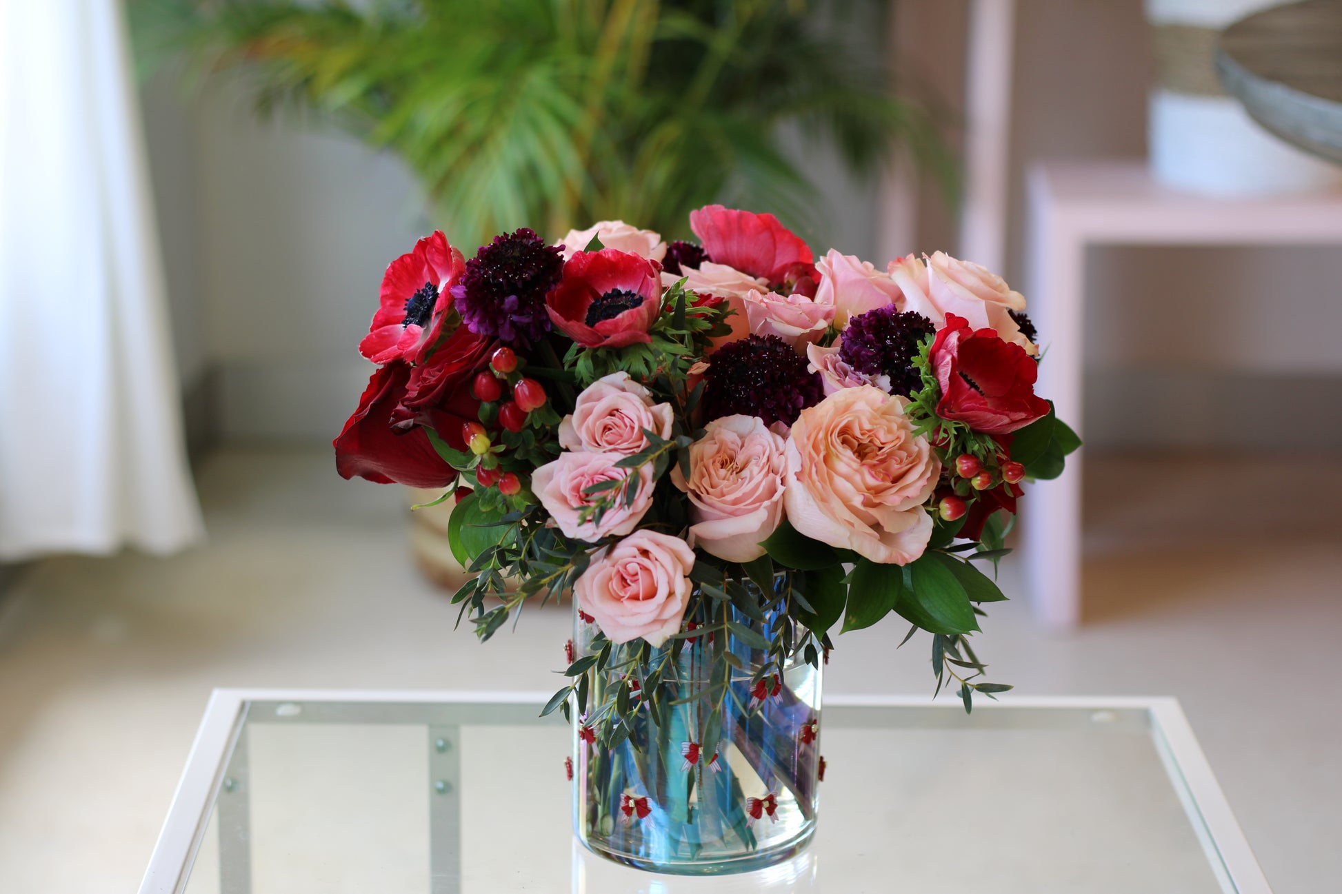 red and blush roses and red anemones