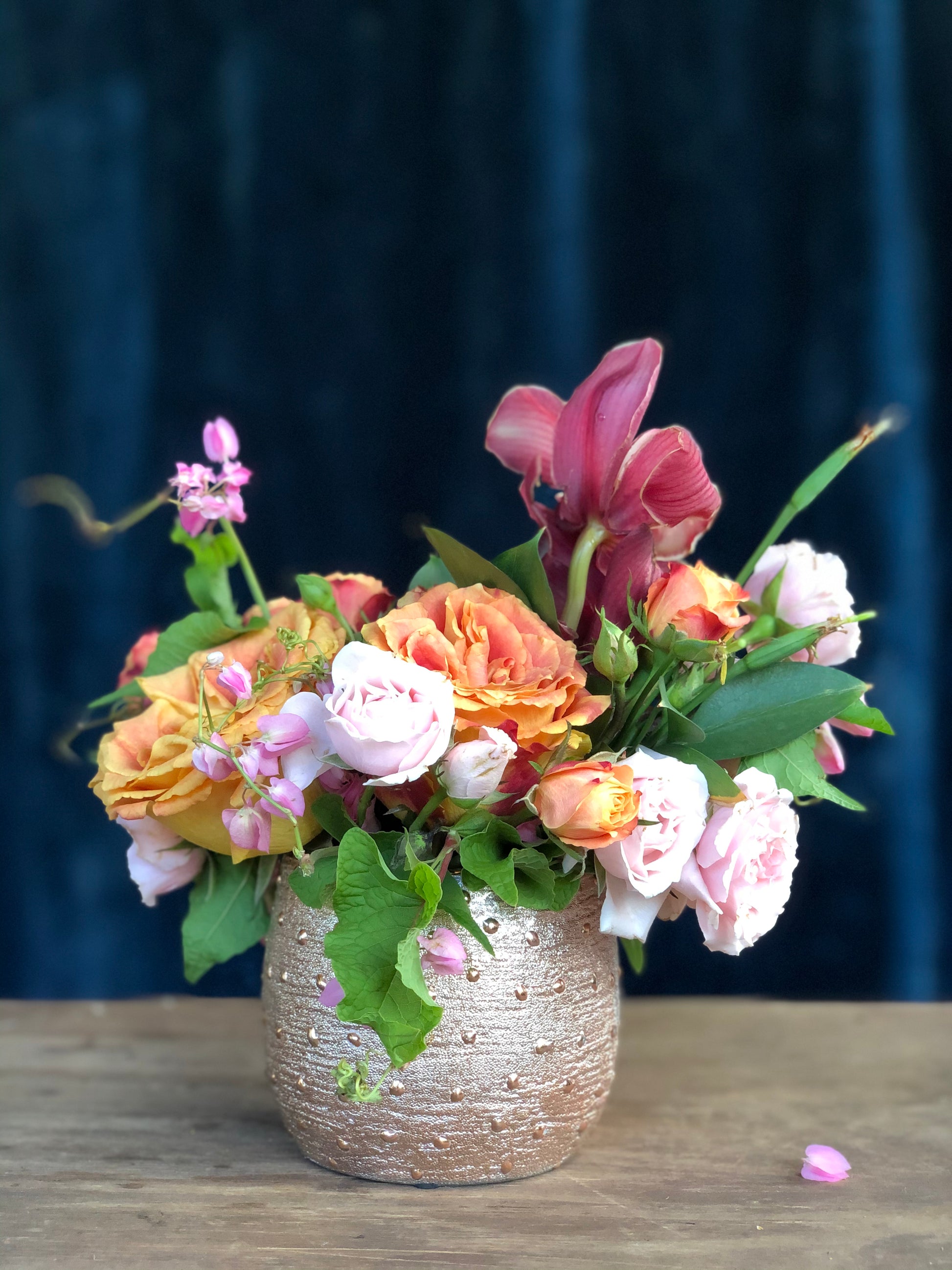 arreglo floral de orquídeas y rosas  pequeño en vase de cerámica en colores de primavera  